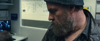 Movie still from “Rust and Bone” (2012), directed by Jacques Audiard – A man with a beard wearing a hat and jacket; Close Up shot, Over the shoulder angle
