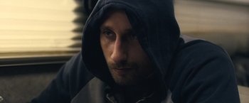 Movie still from “Rust and Bone” (2012), directed by Jacques Audiard – A person wearing a hooded sweatshirt; Close Up shot, Over the shoulder angle