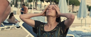 Movie still from “Rust and Bone” (2012), directed by Jacques Audiard – A woman with her eyes closed with her hands on her head; Close Up shot, Low angle