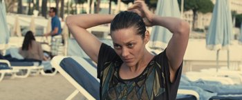 Movie still from “Rust and Bone” (2012), directed by Jacques Audiard – A person holding their hair up; Close Up shot, Over the shoulder angle