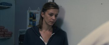 Movie still from “Rust and Bone” (2012), directed by Jacques Audiard – A woman standing next to a white wall; Close Up shot, Over the shoulder angle