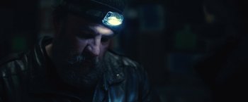 Movie still from “Rust and Bone” (2012), directed by Jacques Audiard – A man with a beard wearing a hat and a headlamp; Close Up shot, Low angle