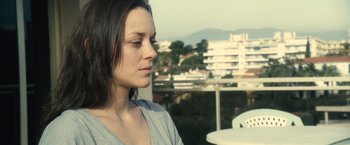 Movie still from “Rust and Bone” (2012), directed by Jacques Audiard – A beautiful woman with long dark brown hair and eyes closed; Close Up shot, Over the shoulder angle