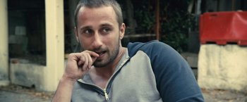 Movie still from “Rust and Bone” (2012), directed by Jacques Audiard – A person sitting down with his mouth open; Close Up shot, Over the shoulder angle