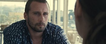 Movie still from “Rust and Bone” (2012), directed by Jacques Audiard – A person sitting in a room; Close Up shot, Over the shoulder angle