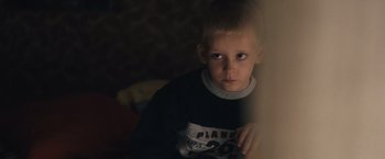 Movie still from “Rust and Bone” (2012), directed by Jacques Audiard – A young boy is looking out a window; Close Up shot, High angle