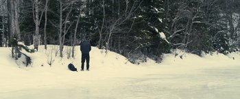 Movie still from “Rust and Bone” (2012), directed by Jacques Audiard – A man standing in the snow next to a tree; Extreme Wide shot, High angle
