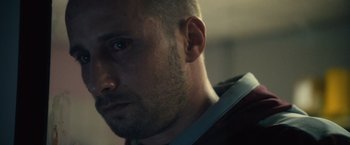Movie still from “Rust and Bone” (2012), directed by Jacques Audiard – A man's face in a dark room; Close Up shot, Low angle
