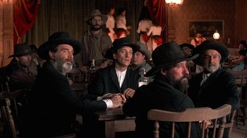 Movie still from “Rustlers' Rhapsody” (1985), directed by Hugh Wilson – A group of men sitting at a table in a room; Medium shot, Low angle
