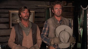 Movie still from “Rustlers' Rhapsody” (1985), directed by Hugh Wilson – A couple of men standing next to each other in a barn; Close Up shot, Low angle