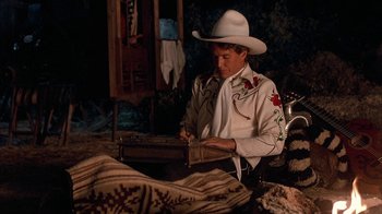 Movie still from “Rustlers' Rhapsody” (1985), directed by Hugh Wilson – A man wearing a white cowboy hat and a white shirt; Medium shot, High angle