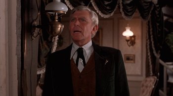 Movie still from “Rustlers' Rhapsody” (1985), directed by Hugh Wilson – An older man wearing a suit and tie in a room; Close Up shot, Low angle