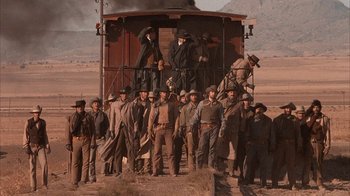 Movie still from “Rustlers' Rhapsody” (1985), directed by Hugh Wilson – A group of men standing on top of a train car; Wide shot, Low angle