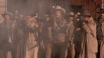 Movie still from “Rustlers' Rhapsody” (1985), directed by Hugh Wilson – A group of men in cowboy hats standing next to each other; Medium shot, Low angle