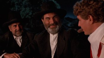 Movie still from “Rustlers' Rhapsody” (1985), directed by Hugh Wilson – An older man wearing a hat and a suit; Close Up shot, Over the shoulder angle