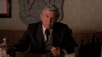 Movie still from “Rustlers' Rhapsody” (1985), directed by Hugh Wilson – An older man sitting at a table in front of a mirror; Close Up shot, Over the shoulder angle