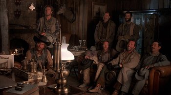 Movie still from “Rustlers' Rhapsody” (1985), directed by Hugh Wilson – A group of men sitting in a living room next to each other; Wide shot, Low angle