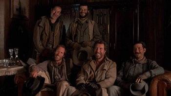 Movie still from “Rustlers' Rhapsody” (1985), directed by Hugh Wilson – A group of men sitting next to each other in a room; Medium shot, Low angle