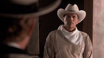 Movie still from “Rustlers' Rhapsody” (1985), directed by Hugh Wilson – A man wearing a cowboy hat and a cowboy outfit; Close Up shot, Over the shoulder angle