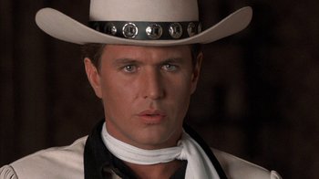 Movie still from “Rustlers' Rhapsody” (1985), directed by Hugh Wilson – A man wearing a white cowboy hat and a white neck scarf; Close Up shot, Low angle