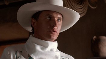 Movie still from “Rustlers' Rhapsody” (1985), directed by Hugh Wilson – A man wearing a white hat and a white shirt; Close Up shot, Low angle