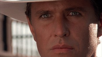 Movie still from “Rustlers' Rhapsody” (1985), directed by Hugh Wilson – A person wearing a hat and looking at the camera; Close Up shot, Low angle