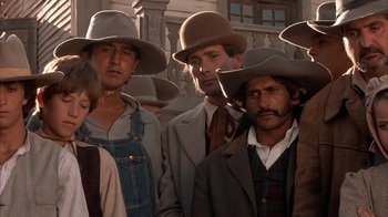 Movie still from “Rustlers' Rhapsody” (1985), directed by Hugh Wilson – A group of men wearing hats and overalls standing next to each other; Medium shot, Low angle