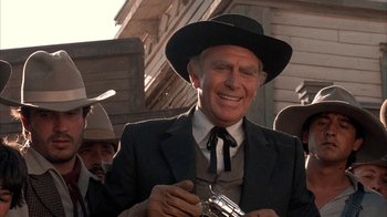 Movie still from “Rustlers' Rhapsody” (1985), directed by Hugh Wilson – An older man wearing a suit and a black hat; Close Up shot, Low angle