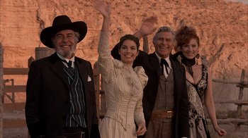 Movie still from “Rustlers' Rhapsody” (1985), directed by Hugh Wilson – A group of people standing next to each other waving; Medium shot, Low angle