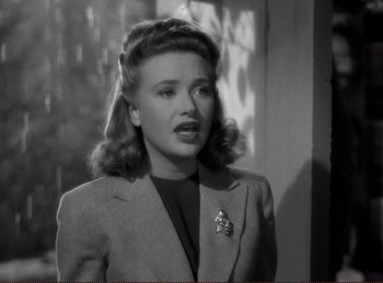 Movie still from “Saboteur” (1942), directed by Alfred Hitchcock – A black and white photo of a woman in a suit; Close Up shot, High angle