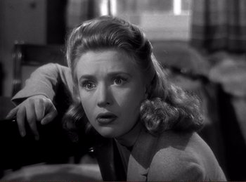 Movie still from “Saboteur” (1942), directed by Alfred Hitchcock – A black - and - white photo of a woman in a suit; Close Up shot, Low angle