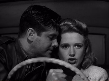 Movie still from “Saboteur” (1942), directed by Alfred Hitchcock – A man and a woman in a black and white photo; Close Up shot, Low angle