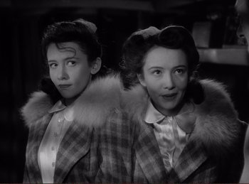 Movie still from “Saboteur” (1942), directed by Alfred Hitchcock – A couple of women standing next to each other; Close Up shot, High angle