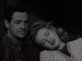 Movie still from “Saboteur” (1942), directed by Alfred Hitchcock – A man and a woman sitting next to each other; Close Up shot, High angle