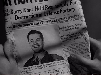 Movie still from “Saboteur” (1942), directed by Alfred Hitchcock – A person holding a newspaper with a picture of a man in a suit; Close Up shot, Overhead angle