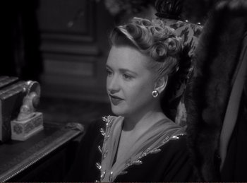 Movie still from “Saboteur” (1942), directed by Alfred Hitchcock – A black and white photo of a woman in a dress; Close Up shot, High angle