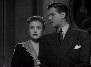 Movie still from “Saboteur” (1942), directed by Alfred Hitchcock – A man and a woman standing next to each other; Medium shot, Low angle