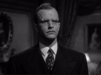 Movie still from “Saboteur” (1942), directed by Alfred Hitchcock – A black and white photo of a man in a suit and tie; Close Up shot, Low angle