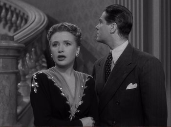 Movie still from “Saboteur” (1942), directed by Alfred Hitchcock – A man and a woman standing next to each other; Medium shot, High angle