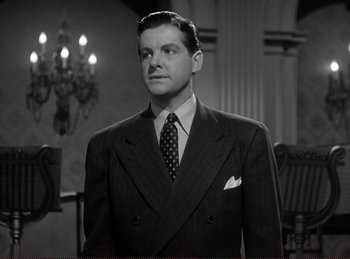 Movie still from “Saboteur” (1942), directed by Alfred Hitchcock – A black and white photo of a man in a suit and tie; Close Up shot, Low angle