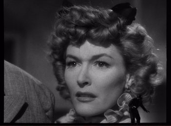 Movie still from “Saboteur” (1942), directed by Alfred Hitchcock – An old photo of a woman with a bird on her head; Close Up shot, Over the shoulder angle