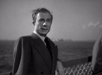 Movie still from “Saboteur” (1942), directed by Alfred Hitchcock – A black and white photo of a man in a suit; Close Up shot, Low angle