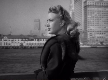 Movie still from “Saboteur” (1942), directed by Alfred Hitchcock – A young woman in a fur coat looks out over the water; Close Up shot, Low angle