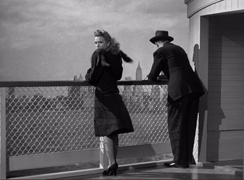 Movie still from “Saboteur” (1942), directed by Alfred Hitchcock – A man and a woman standing next to a railing; Medium shot, Low angle