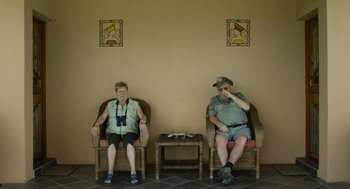 Movie still from “Safari” (2016), directed by Ulrich Seidl – A man and a woman sitting in chairs next to each other; Medium shot, High angle