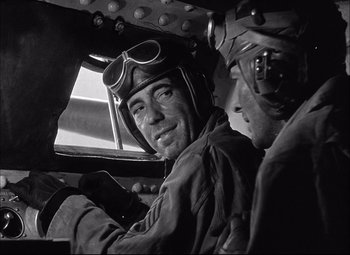 Movie still from “Sahara” (1943), directed by Zoltan Korda – A man in a pilot's uniform and a man in an airplane cockpit; Close Up shot, Low angle