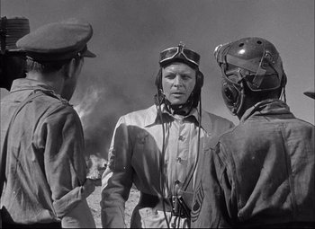 Movie still from “Sahara” (1943), directed by Zoltan Korda – A group of men standing next to each other on top of a hill; Medium shot, Over the shoulder angle