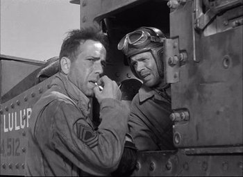 Movie still from “Sahara” (1943), directed by Zoltan Korda – Two men in military fatigues are looking out of a train window; Medium shot, Low angle