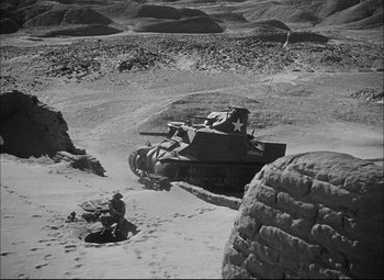 Movie still from “Sahara” (1943), directed by Zoltan Korda – An old military tank in the middle of the desert; Extreme Wide shot, High angle