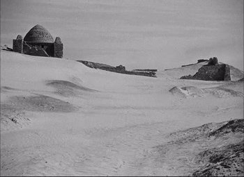 Movie still from “Sahara” (1943), directed by Zoltan Korda – A black - and - white photo of a snow covered field; Extreme Wide shot, Low angle